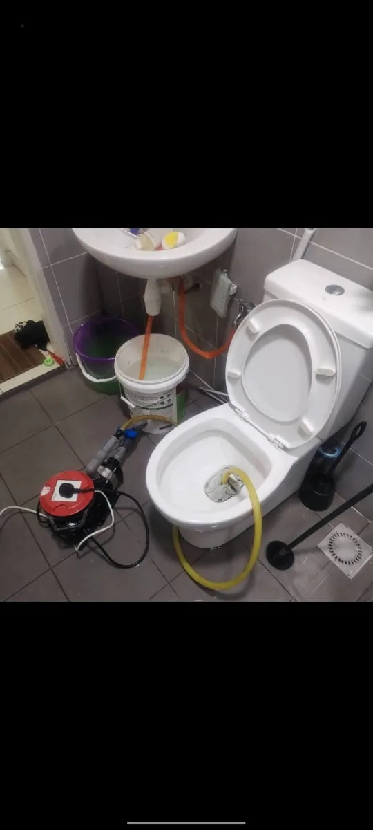 Drain-clearing machine connected to a blocked toilet