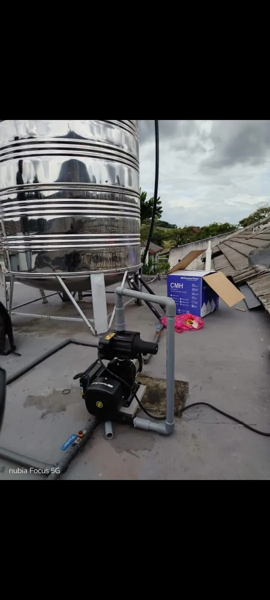 New water pump connected beside a rooftop storage tank