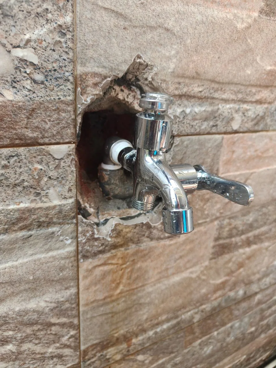 Wall-mounted tap connected to repaired pipework
